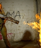 Sarah, blonde, strip, handgun, flame thrower